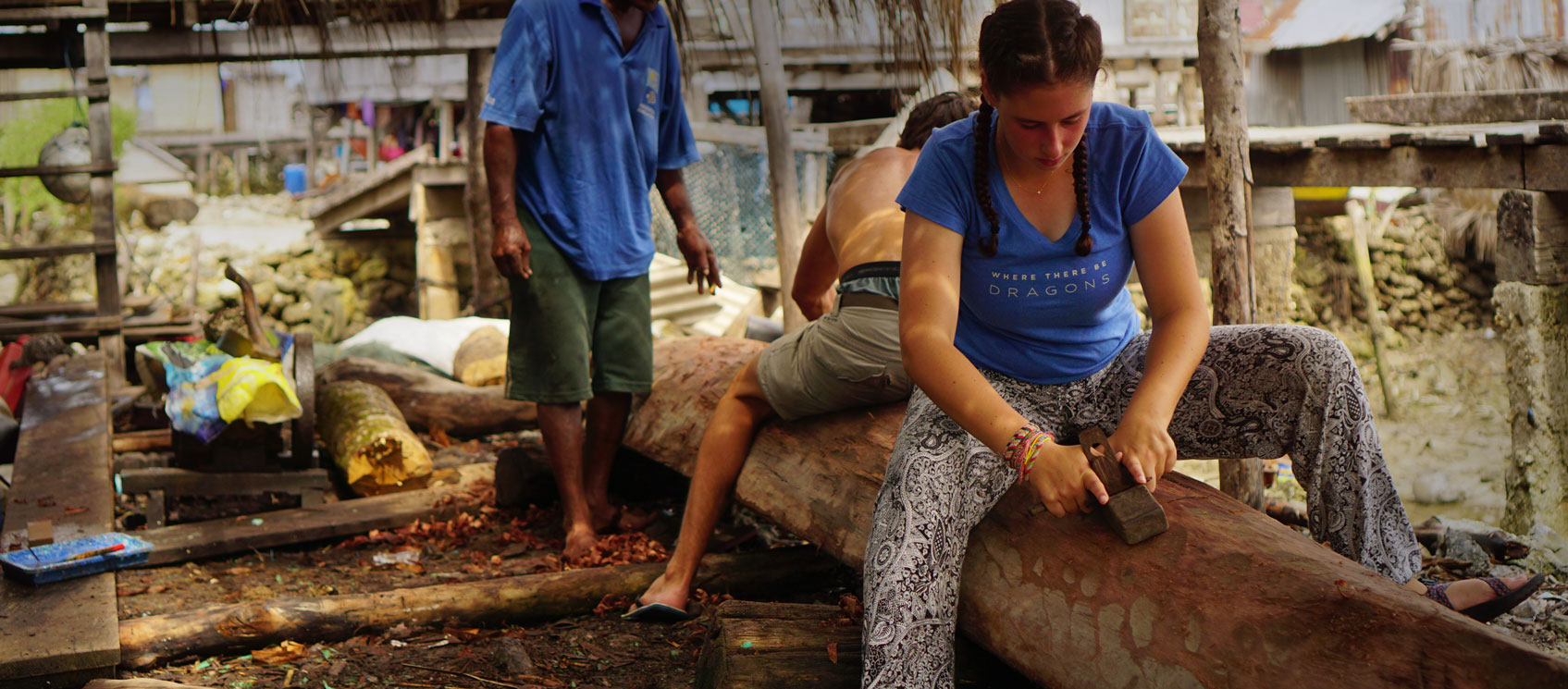 students carving dugout canoe