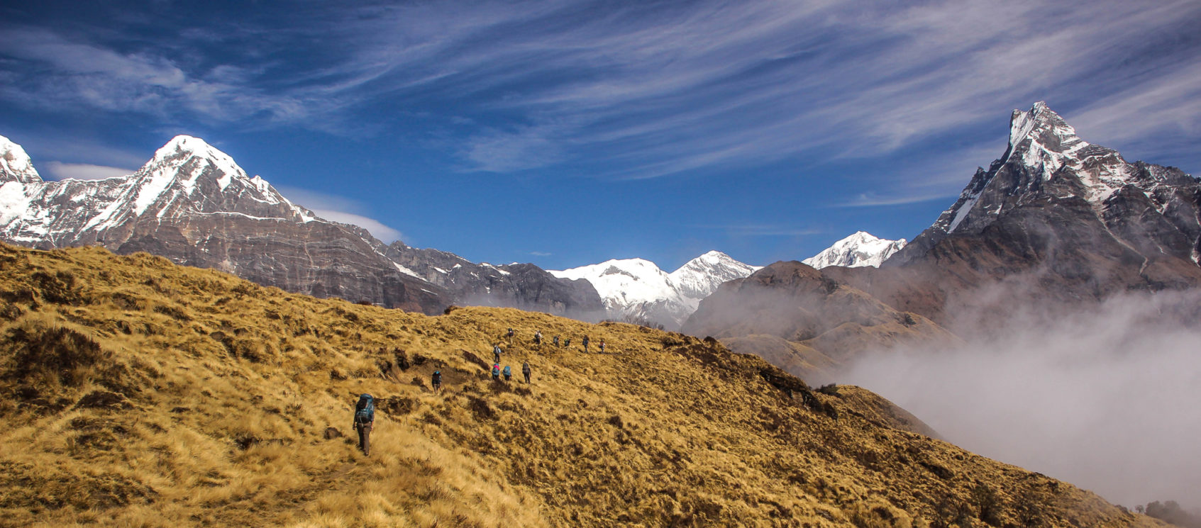 12 Hikers Trekking in rugged Nepal mountains