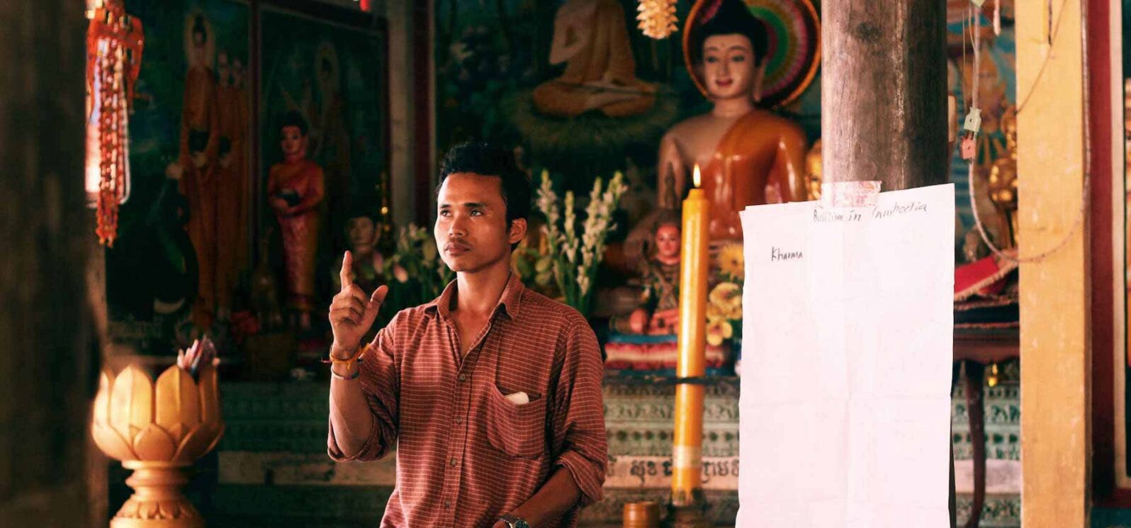 teacher kneeling while giving a lecture
