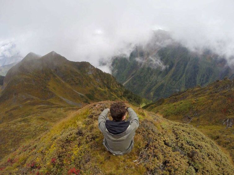 Young boy sitting overlooking foggy mountains
