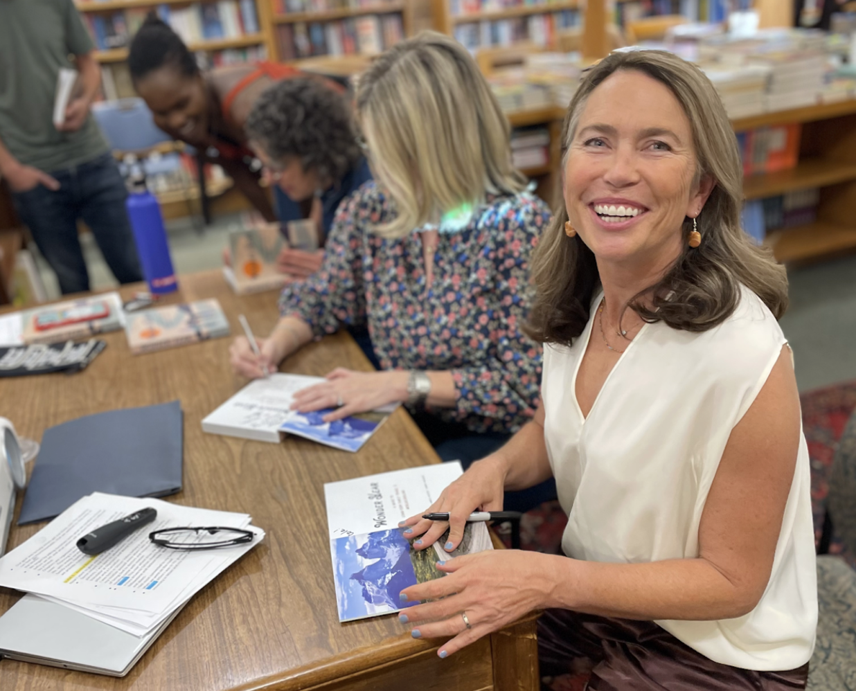 Woman smiles at camera during book-signing