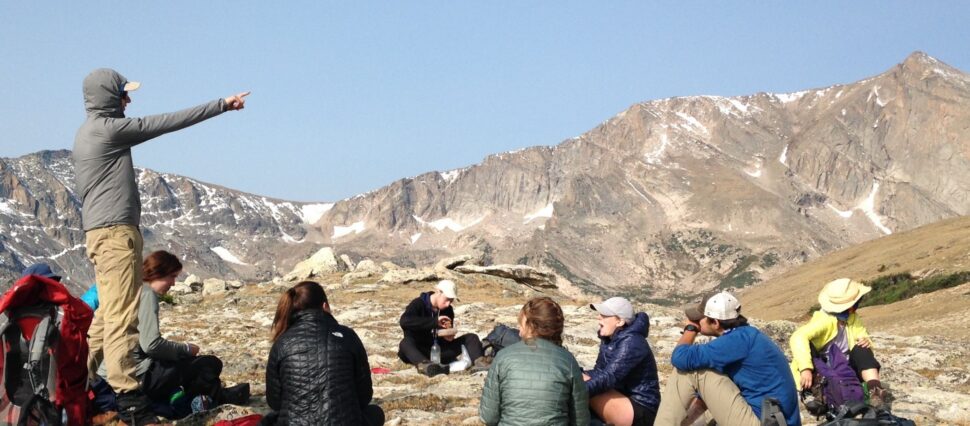 man pointing to mountains